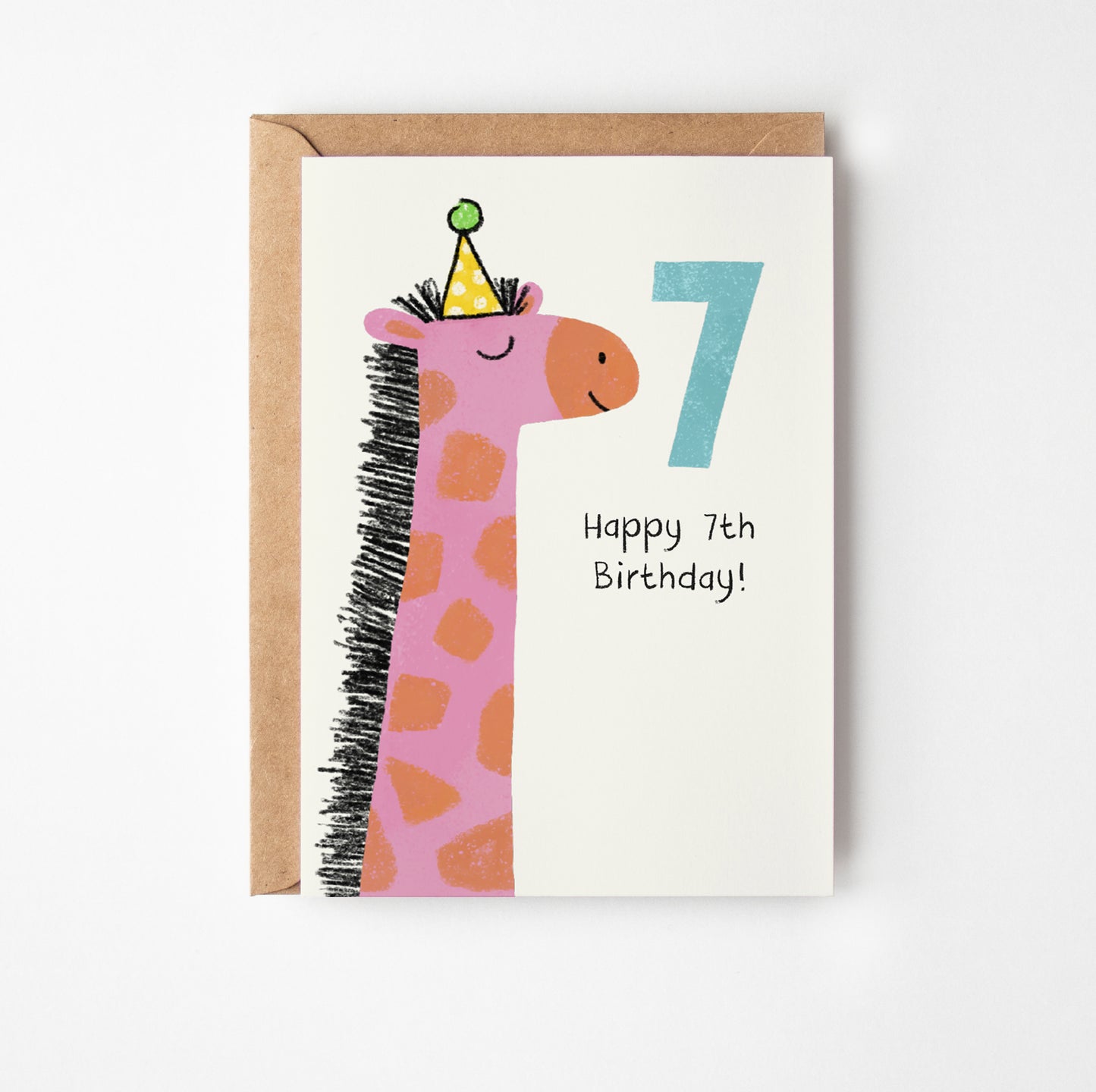 A greeting card with a kraft envelope, featuring a cute pink giraffe wearing a party hat next to a large number 7 and the text 'Happy 7th Birthday!' on a white card.